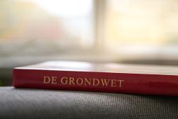 Boek met daarop de tekst "De grondwet"